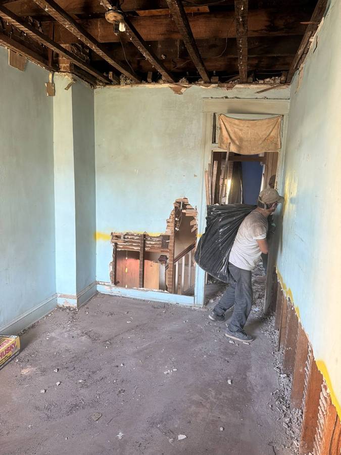Crew member pulling damaged material from a doorway